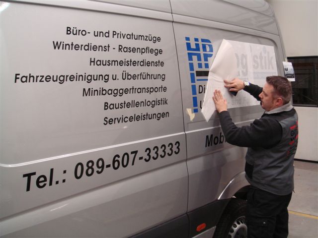 Günther Wagner bei der Montage einer Fahrzeugbeschriftung